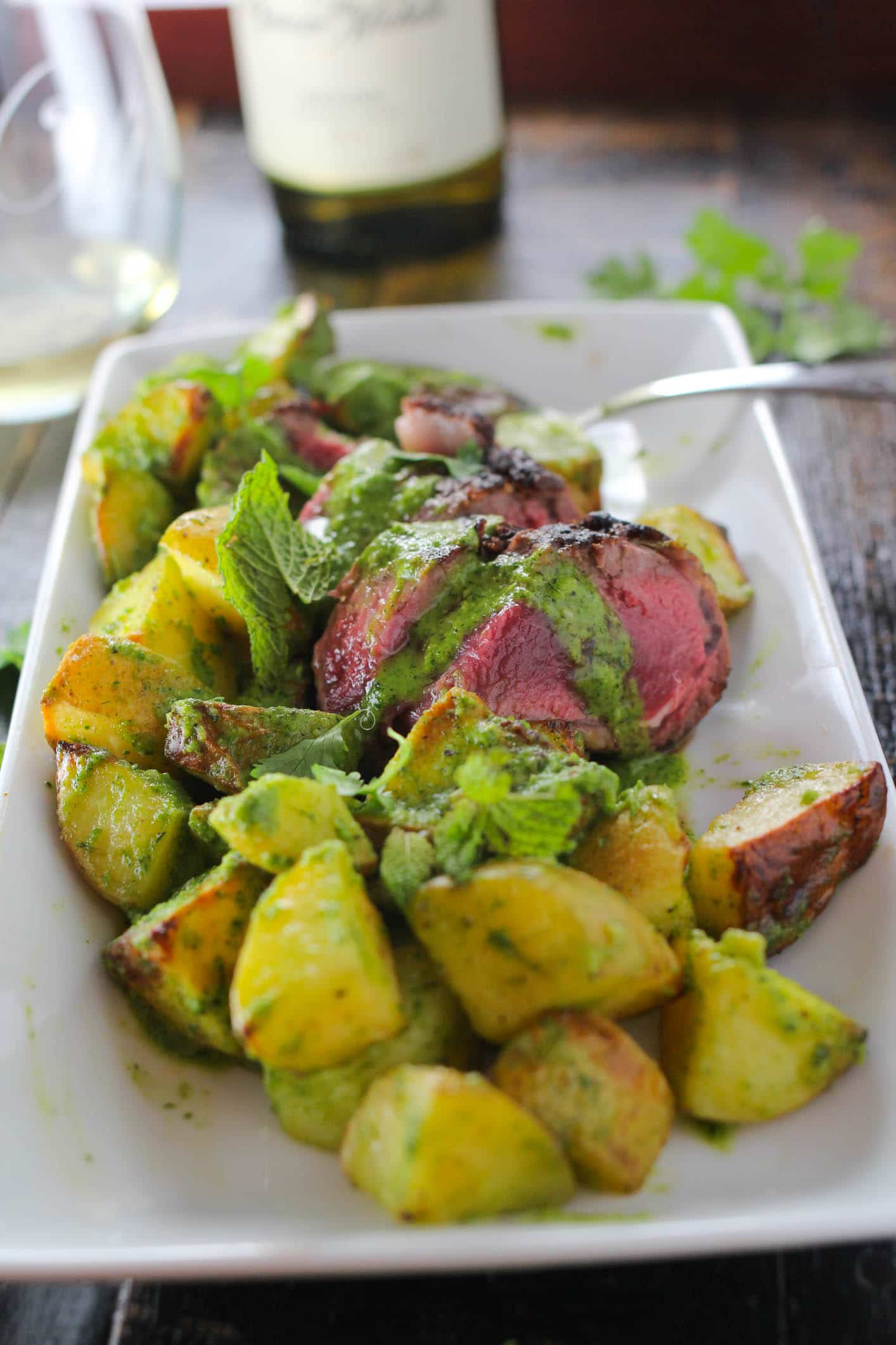 A simple and elegant one pan roasted lamb and potato recipe cooked to perfection and drizzled with an herb infused chimichurri.