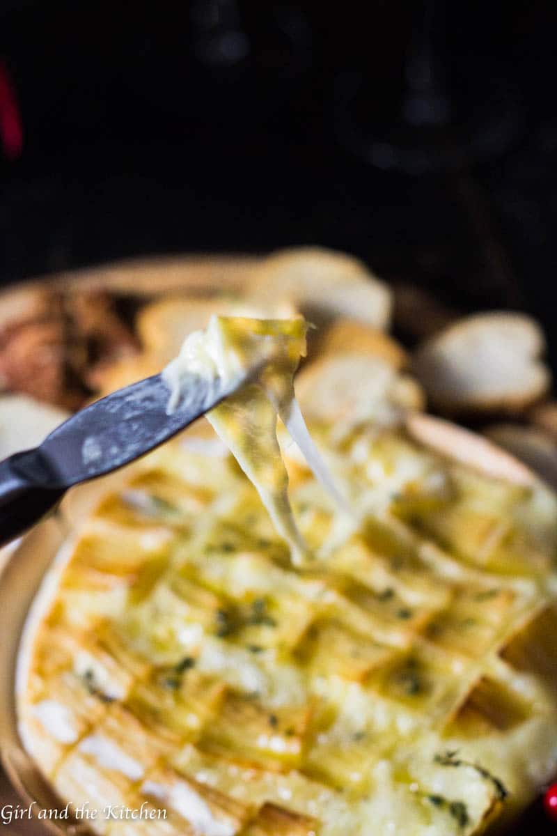 This gooey garlic baked brie has only 4 ingredients and takes 15 minutes to prepare! It comes out of the oven gooey and cheesy and loaded with rich garlic and herb flavors! This is the ultimate holiday appetizer for any party!