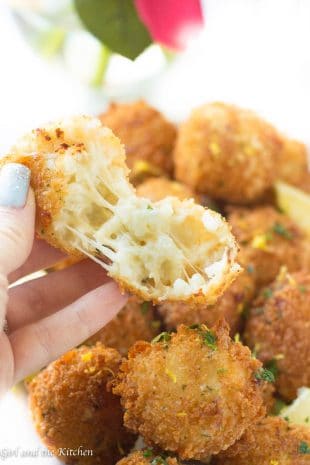 These incredible little Italian Rice Balls are loaded with cheese and make perfect party treats! Loaded with plenty of cheese and tender risotto these crispy little balls of flavor are best freshly fried but best of all they are just as good made ahead and baked!