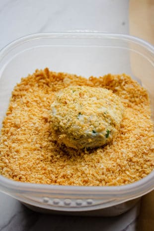 crab cake being dipped in bread crumbs