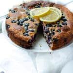 serving plate with French yogurt blueberry cake topped with lemon slices