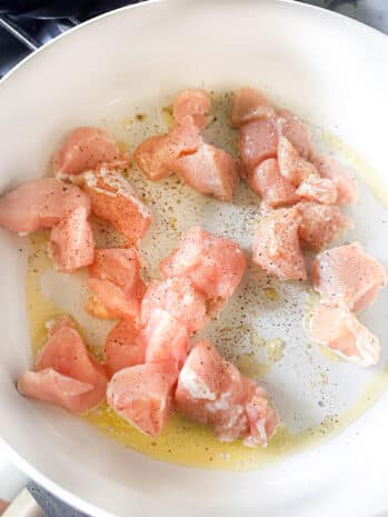 chicken is fried in a frying pan