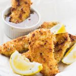 Learn how to make incredibly crunchy baked chicken tenders that are uber flavorful and moist! I serve them with my multi purpose and super delicious Honey Mustard Dressing that makes these chicken tenders irresistible to adults and children!